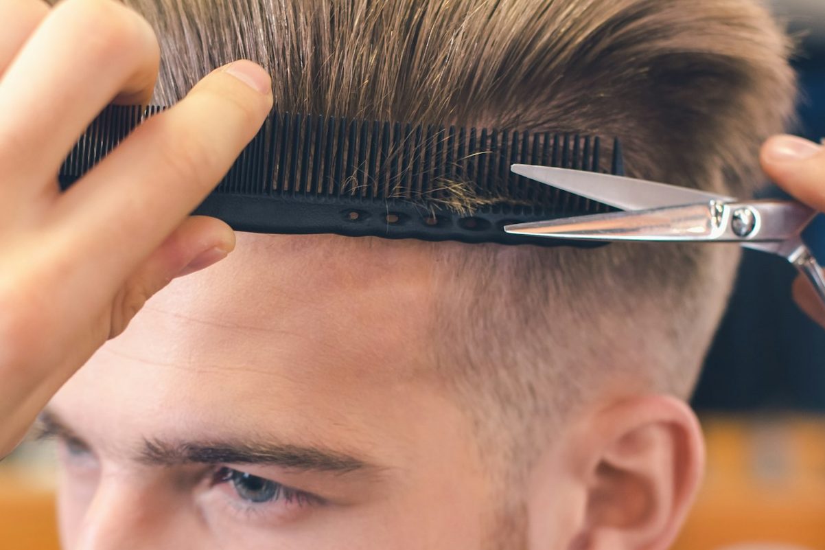 Einem Mann werden die Haare geschnitten